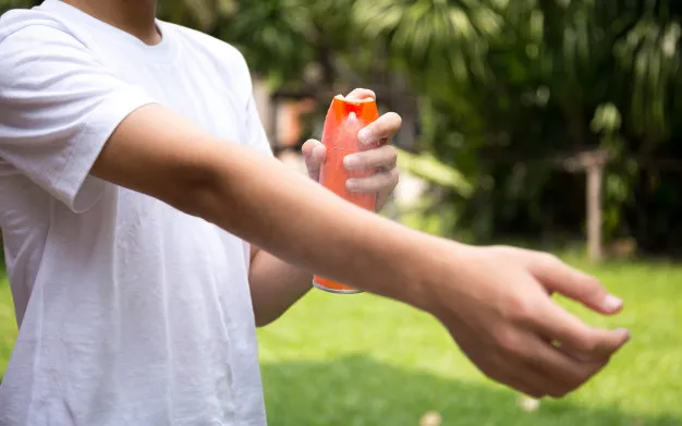 chico-joven-rocia-repelentes-insectos-piel-botella-spray_42667-43
